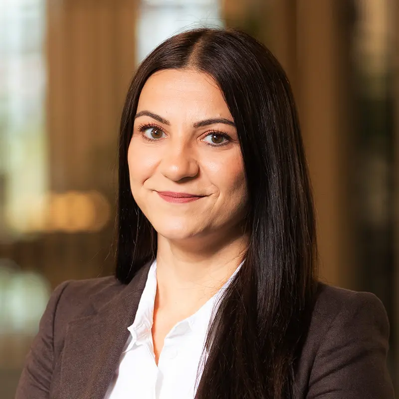 Porträtaufnahme von Martina, Mitarbeiterin im Team von TRUST Personal im dunklen Blazer.
